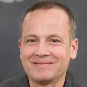 Smiling man with short hair in a dark shirt